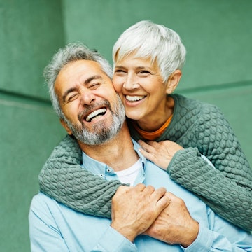 Mature couple with dental implants laughing and smiling