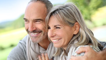 Older couple smiling together showing there porcelain veneers