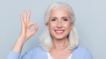 older woman smiling giving okay hand sign